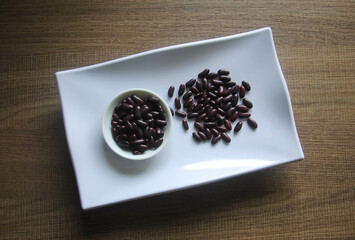 Organic kidney beans in white plate on wooden table.The kidney bean is a variety of the common bean (Phaseolus vulgaris).