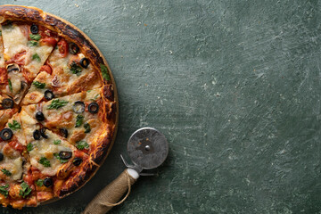 Delicious vegetarian tomato and cheese pizza with greens on a green stone background, Close-up top view
