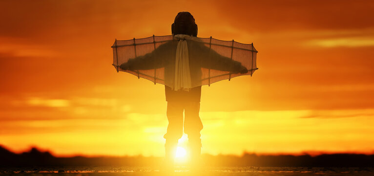 Little boy with wings at sunset imagines himself a pilot and dreams of flying.