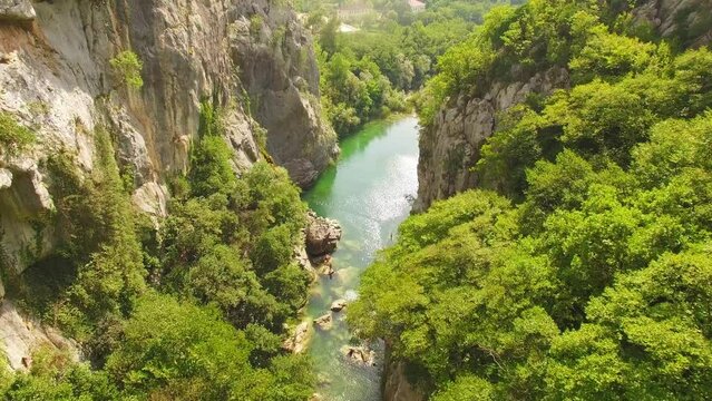 Drone flying over river, green nature and rocks.