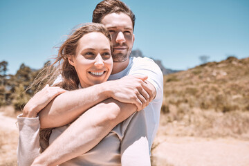 Romantic, happy and in love young couple hugging together in outdoors nature walk, enjoying dating relationship and bonding time. Loving husband and wife holding each other in sweet caring embrace