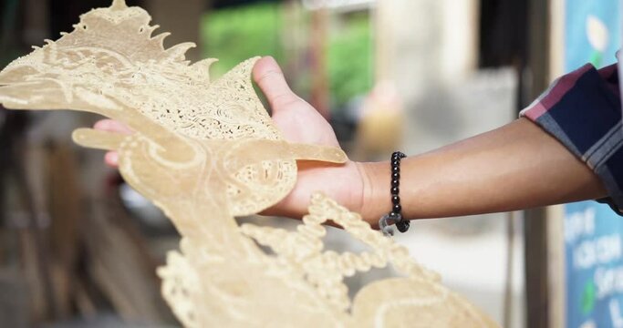Youth hands showing processed shadow puppets. Wayang kulit is a traditional form of puppet-shadow play originally found in the cultures of Java, Bali, and Lombok in Indonesia.