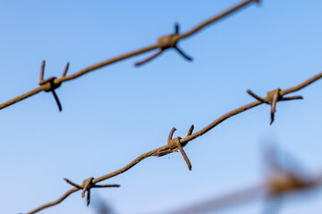 Old barbed wire against the blue sky