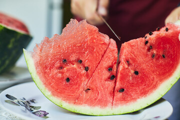 Juicy red watermelon is cut with a knife. The concept of summer and delicious vegetables. Front...