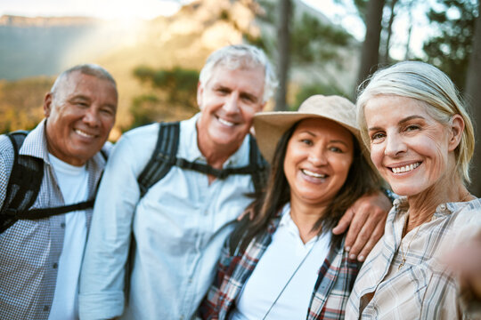 Hiking team taking a selfie in the natural woods, mountains and forest outdoors together in nature. Healthy, happy and senior couples outside on holiday to keep active, friendship and fit on a hike