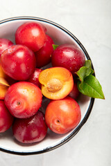 Plate of fresh ripe plums on table.