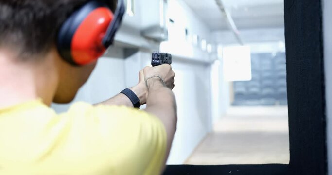 Professional train in shooting from a pistol in shooting range