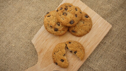 Chocolate cookies with on wooden cutting board and on burlap surface