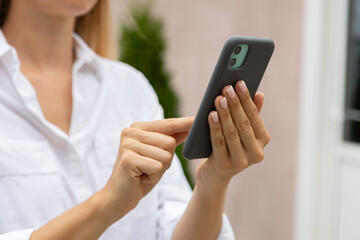 female hands hold a modern mobile phone on the street..education, modern app, shopping order, work online