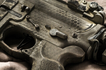 Close-up shot of selective fire of khaki camouflage M4 assault rifle, to be adjusted to fire in safe, semi-automatic, fully automatic firearm
