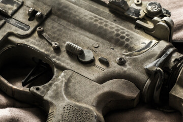 Close-up shot of selective fire of khaki camouflage M4 assault rifle, to be adjusted to fire in safe, semi-automatic, fully automatic firearm
