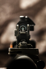Close-up of flip rear sight and charging handle of assault rifle AR15 khaki camouflage