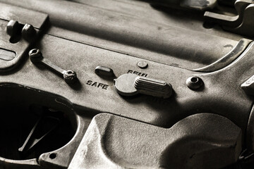 Close-up shot of selective fire of khaki camouflage M4 assault rifle, to be adjusted to fire in...