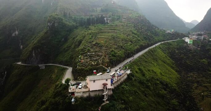 An aerial moves up a mountain over a popular lookout on the Ma Pi Leng Pass scenic winding tourist drive. North Vietnam.
