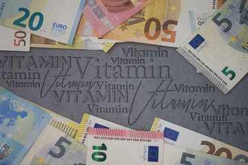 Vitamin word with money. Paper currency background with different banknotes.