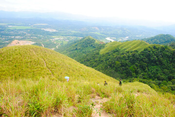 Obraz premium Panoramic view of green hill on a sunny summer day. Hiking adventure concept