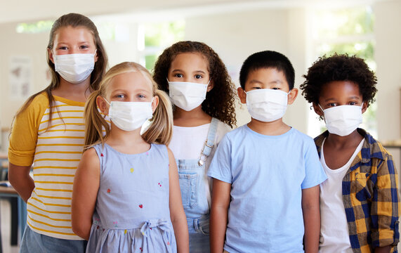 School Kids, Education And Covid While Wearing Face Masks In A Classroom For Protection Against Covid. Portrait Of Cute, Young And Smart Students In Safe Learning And Educational Environment Together