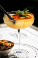Cocktail with dried orange and mint garnish with bar snacks