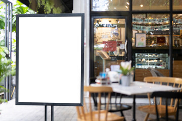 White blank signboard stand near the entrance to the coffee shop, mock up, cafeteria blurred background can inserting the text of the customer.