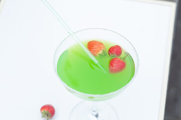 Colorful bright green cocktail cactus with strawberries, delicious refreshing