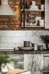 details of a cozy view of the kitchen interior in a rustic style with lamps and a fir tree decorated for Christmas