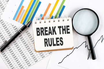 BREAK THE RULES text on notebook on the graph background with pen and magnifier