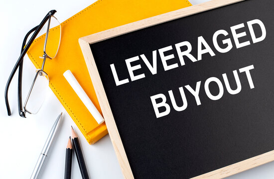 LEVERAGE BUYOUT Text On Blackboard With Notepad , Pen, Pencil