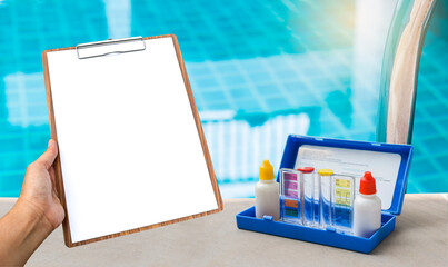 Clipboard with water tester test kit on swimming pool edge, water quality check list, swimming pool...