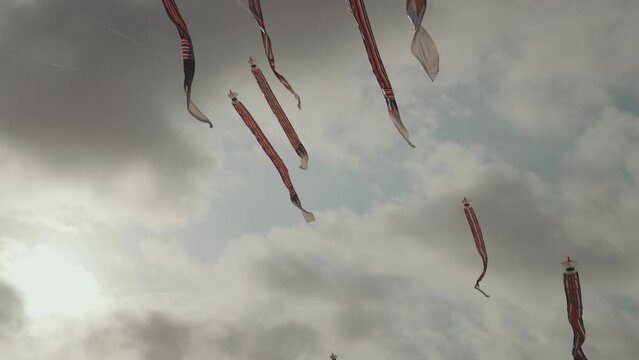 Balinese Traditional Kites JANGGAN (Red White Black Long Tail Bird Dragon) on Bali Kite Festival Summer Blue Sky Slow Motion