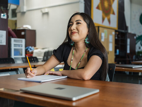 Native girl with jewelry smiles at the whiteboard during class