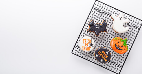 Halloween gingerbread cookies on baking rack on white background. Bright homemade cookies for...