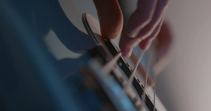 Close up of bass guitar finger picking in slow motion.