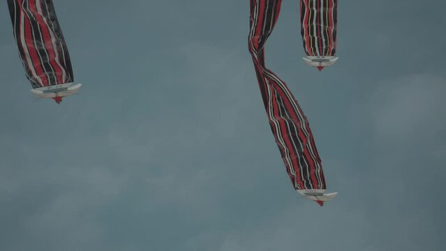 Balinese Traditional Kites JANGGAN (Red White Black Long Tail Bird Dragon) on Bali Kite Festival Summer Blue Sky Slow Motion