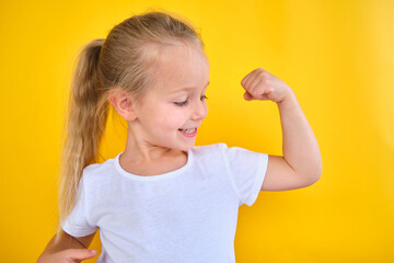 portrait Strong preschool little girl showing flexing arm muscle smile isolated 