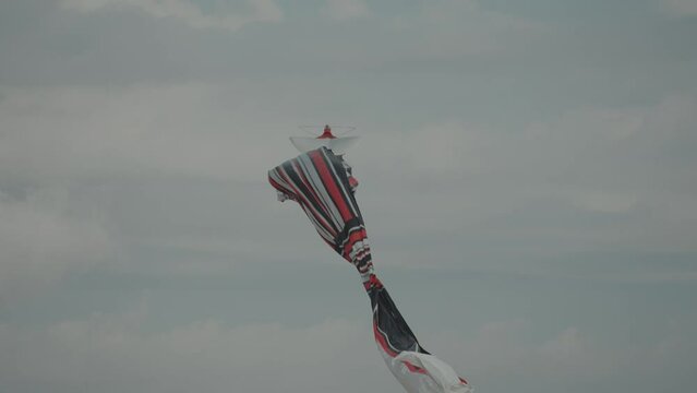 Balinese Traditional Kites JANGGAN (Red White Black Long Tail Bird Dragon) on Bali Kite Festival Summer Blue Sky Slow Motion
