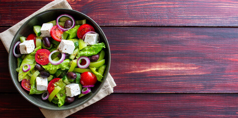 Greek salad with feta cheese, tomatoes, cucumbers, peppers and Kalamata olives. Healthy eating. Vegetarian food.