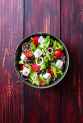 Greek salad with feta cheese, tomatoes, cucumbers, peppers and Kalamata olives. Healthy eating. Vegetarian food.