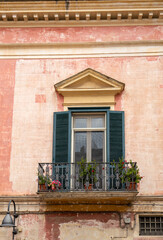 Facade of the house with shutters and small balcony in Matera. Basilicata, Italy