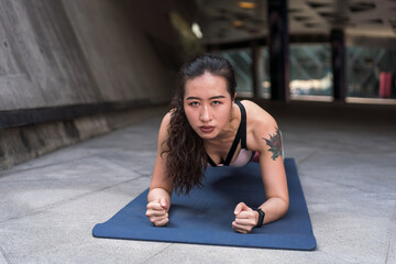 Naklejka na ściany i meble Asian woman exercising on yoga mat