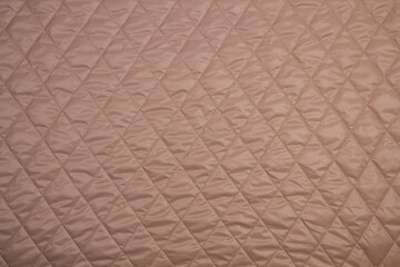 Top view quilted fabric. The texture of the blanket. Soft quilted blanket as background, top view	