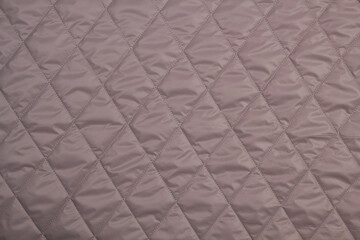 Top view quilted fabric. The texture of the blanket. Soft quilted blanket as background, top view	