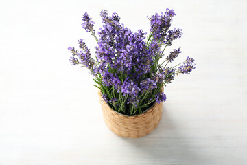 Wicker pot with lavender on wooden background