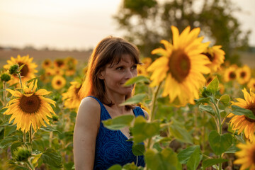 beautiful woman enjoying the summer sun on sunflower field