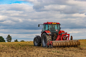 Tractor in european countryside. Harvest season.