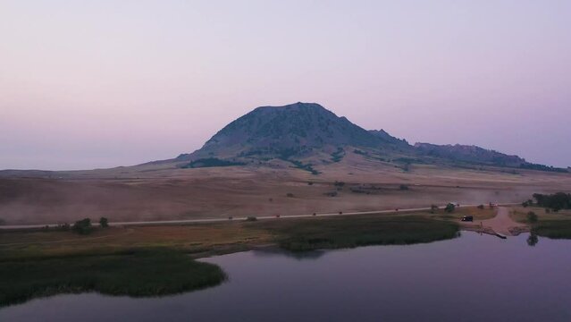 Aerial of motorcyclists on lakeside road in South Dakota, USA. Mountain scenic background