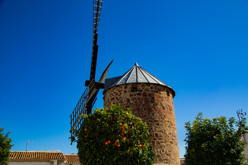Molino de viento de piedra con aspa y puertas de madera