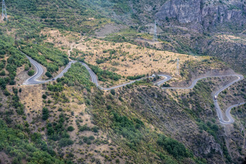 Fototapeta na wymiar mountain gorge with a steep road and a funicular line in the mountains of Armenia