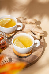  Cup of hot tea with ginger, honey and lemon on the beige background vertical photo