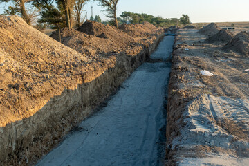 Deep trench in the ground for laying pipes. Water supply or sewerage. Construction site