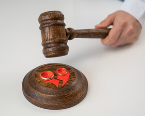 The judge hits the gavel on a broken heart and wedding rings.